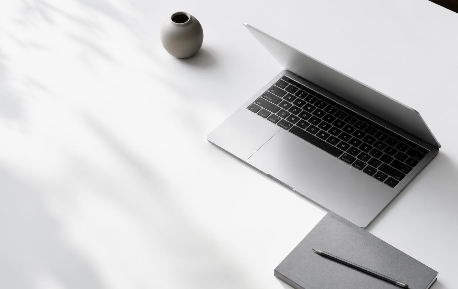 Bureau épuré avec ordinateur portable et carnet